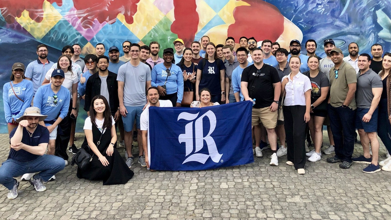 Rice MBA students outside with their hands up during the MBA global field experience