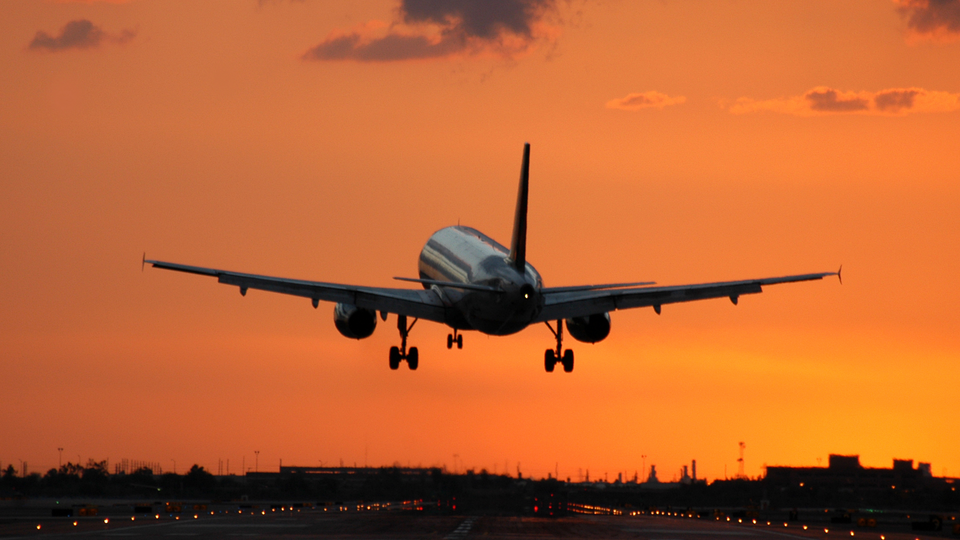 Plane flying out into sunrise