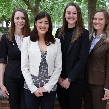 Five Rice female MBA board fellow students wearing suits outside