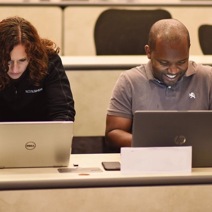 man and woman working on computers